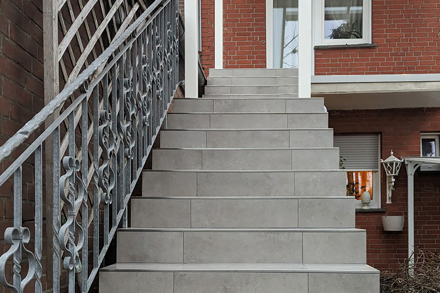 Blick auf eine hell geflieste Treppe im Außenbereich eines Hauses